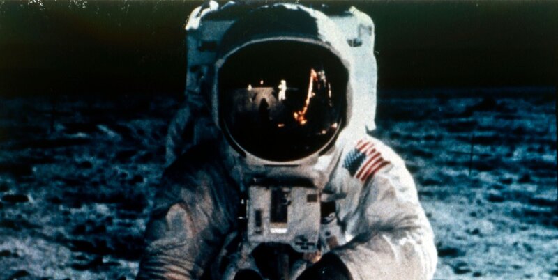 Buzz Aldrin auf dem Mond, Apollo II-Mission, Juli 1969. In Aldrins Visier spiegeln sich Neil Armstrong, der das Foto macht, die US-Flagge und der „Eagle“. Die Mondlandefähre Apollo 11, Codename Eagle, mit den US-Astronauten Neil Armstrong und Buzz Aldrin an Bord, landete am 20. Juli 1969 im Meer der Ruhe. Apollo 11 war die fünfte bemannte Apollo-Mission und die erste, die auf dem Mond landete. Künstler Neil Armstrong. – Bild: Photo by Heritage Space/​Heritage Images/​Getty Images