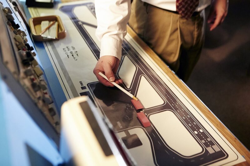 REENACTMENT – A Tenerife controller (played by background performers) moves erasers along a diagram where planes should be. (Photo Credit: Cineflex/​Ian Watson) – Bild: PLURIMEDIA (Cineflix /​ Ian Watson)