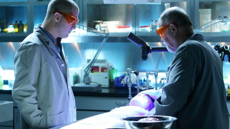 Nick (George Eads, li.) und Doc Robbins (Robert David Hall) haben die traurige Aufgabe, den tot aufgefundenen Jungen zu untersuchen, um die Todesursache herauszufinden. – Bild: TVNOW /​ CBS