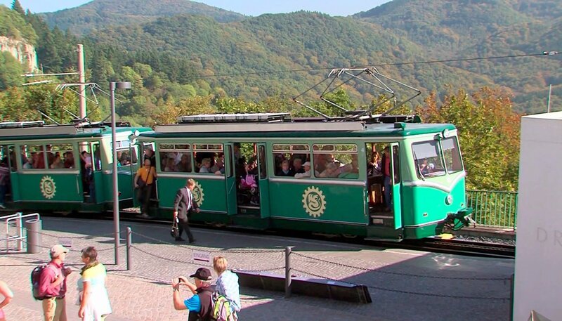 Unterwegs auf den Zugstrecken der Welt. Draußen ziehen tolle Berge und Täler vorbei, reißende Flüsse werden passiert. Die Tour auf diesen Eisenbahnrouten ist ein Vergnügen. – Drachenfelsbahn in Königswinter. – Bild: rbb/​SWR