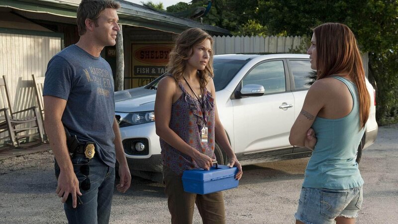 Die Witwe des Opfers, Shelby Daniels (Willa Ford, r.) macht sich für Jim (Matt Passmore) und Callie (Kiele Sanchez) verdächtig, denn sie wirkt zunächst wenig berührt vom Tod ihres untreuen Mannes. – Bild: TVNOW