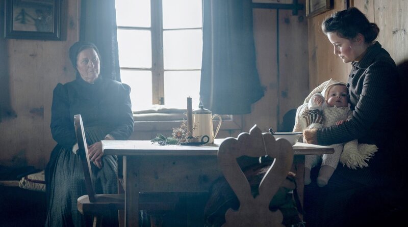 Nur ein kurzer Moment des Glücks: Johanna (Dominique Devenport) mit ihrem Kind. Gertrud Donatsch (Charlotte Schwab, li.) passt auf. – Bild: ORF/​Global Screen/​SRF/​ARD Degeto/​Amalia Film/​Contrast Film/​Letterbox Filmproduktion/​Pascal Mora