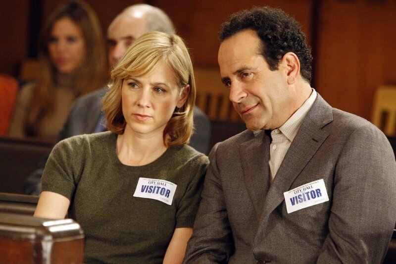 Monk (Tony Shalhoub) und Natalie (Traylor Howard) verfolgen gespannt die Abstimmung im Stadtrat, bei der es um den Abriss des Parkhauses geht, in dem Monks Frau Trudy gestorben ist. – Bild: RTLplus /​ Universal