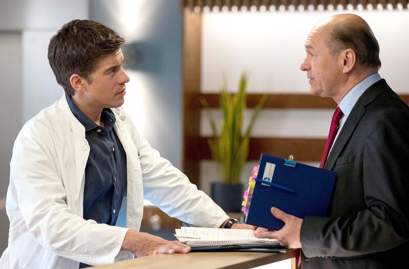 Wolfgang Berger (Horst Günter Marx, r.) kommt mit einer Ladung Papierkram auf Dr. Ben Ahlbeck (Philipp Danne, l.). – Bild: ARD/​Jens-Ulrich Koch