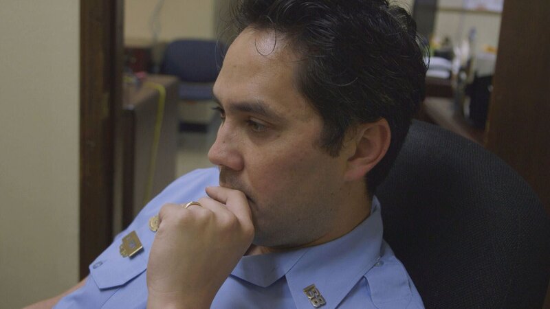 Der Polizist setzt sich auf einen Stuhl und denkt nach – Bild: boxftp Unit /​ © Crime + Investigation /​ A+E Networks