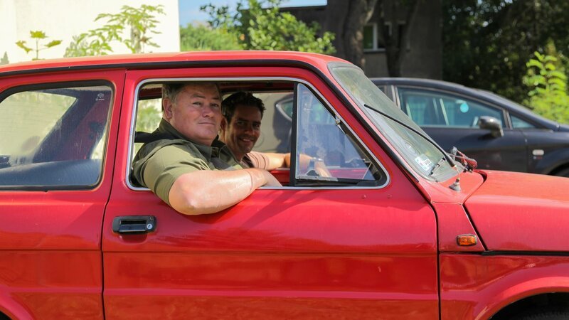 L-R: Mike and Elvis posing inside car. – Bild: Warner Bros. Discovery, Inc.