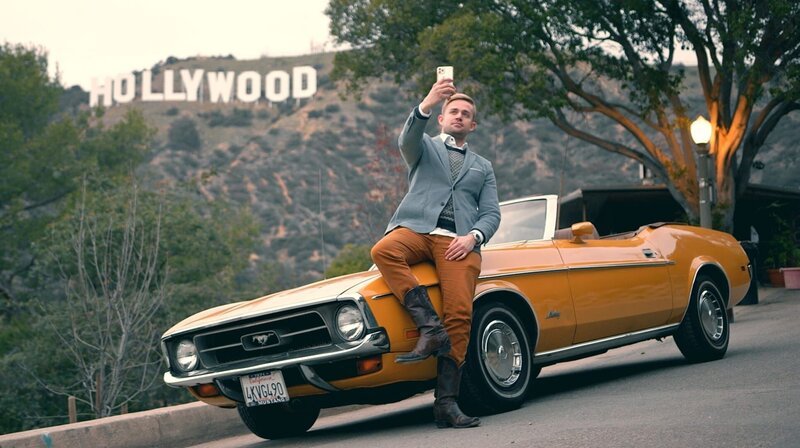 Marcel Goldhammer lehnt an einem Ford Mustang vor dem Hollywood-Monument. – Bild: HR/SWR/Glotzenoff/André Krummel Marcel Goldhammer lehnt an einem Ford Mustang vor dem Hollywood-Monument. – Bild: HR/SWR/Glotzenoff/André Krummel