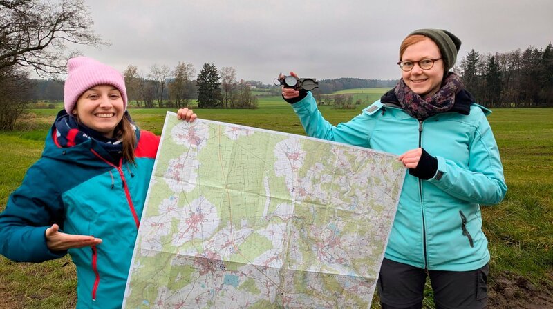 Marina (links) checkt mit Orientierungs-Expertin Julia, wie man sich mit Karte und Kompass orientiert. Weiteres Bildmaterial finden Sie unter www.br-foto.de. – Bild: BR/​megaherz gmbh/​Judith Issig
