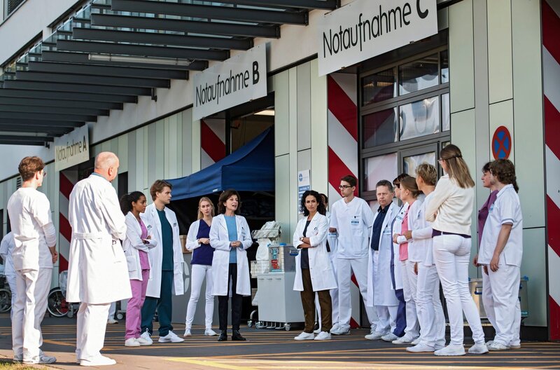 Nach einem Massenunfall werden mehrere Patienten am Johannes-Thal-Klinikum erwartet. Karin Patzelt und Leyla Sherbaz geben ihrem Team Anweisungen. V.l.n.r.: Komparasin, Komparse, Emma Jahn (Elias Agbaglah), Mikko Rantala (Luan Gummich), Komparsin, Karin Patzelt (Marijam Agischewa), Leyla Sherbaz (Sanam Afrashteh) und Komparsen. – Bild: ARD/​Jens Ulrich Koch