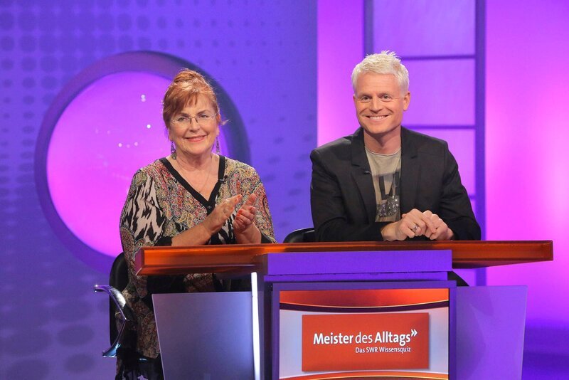 Das Rateteam Alice Hoffmann und Guido Cantz ist bereit für kniffelige Fragen aus dem prallen Leben beim Wissensquiz „Meister des Alltags“. – Bild: SWR/​Peter A. Schmidt