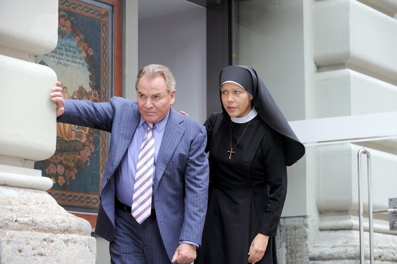 Nach dem Besuch bei der Mutter Oberin töstet Schwester Hanna Bürgermeister Wöller (v.li.: Fritz Wepper, Janina Hartwig). – Bild: ORF/​Kineos/​Barbara Bauriedl