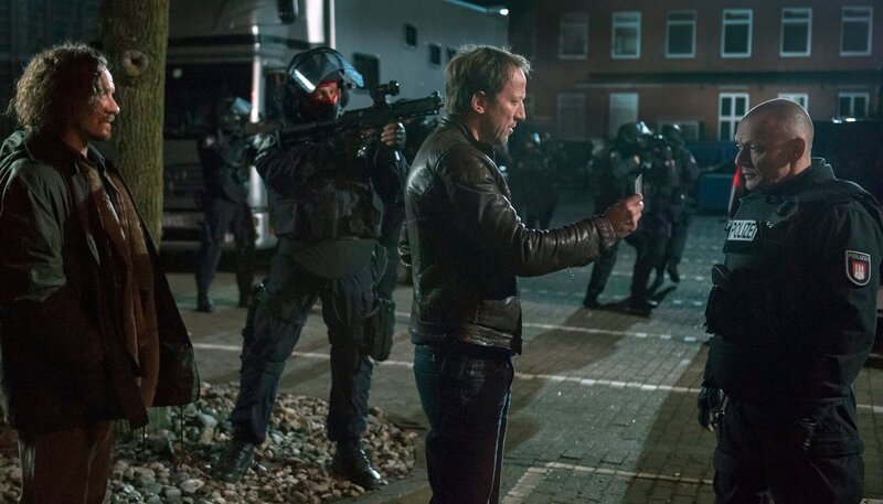 Falke (Wotan Wilke Möhring) und Ex-Bunny Axel (Tim Grobe) im Gespräch mit der SEK-Einsatzleitung (Torsten Michaelis). – Bild: NDR/​Christine Schroeder