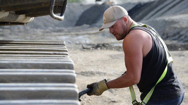 Brennan Ruault cleaning the excavator tracks. – Bild: DMAX