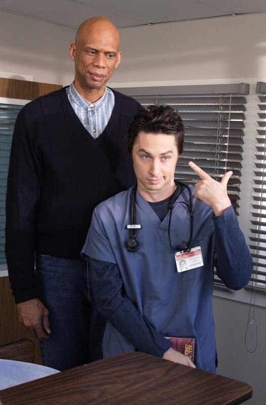 „Scrubs – Die Anfänger“, „Mein Schützling.“ J.D. kann Assistenzarzt Keith nicht ausstehen, der ekelhaft perfekt ist und zudem eine Affäre mit Elliot hat. Er lässt keine Möglichkeit aus, dem Konkurrenten Fehler unterzuschieben und schreckt nicht einmal davor zurück, Keiths Kündigung zu verlangen. Inzwischen fühlt sich Dr. Kelso von einem Vogel gestört, der im Krankenhaus zu nisten begonnen hat. Der Hausmeister soll das Tier entfernen, bringt es jedoch nicht übers Herz.Im Bild (v.li.): Karim Abdul-Jabbar (Kareem Abdul-Jabbar), Zach Braff (John ‚J.D.‘ Dorian). – Bild: ORF/​Disney/​Paul Drinkwater