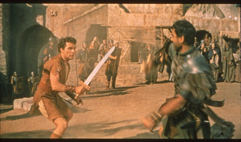 Marcellus (Richard Burton, links) macht sich den späteren Kaiser Caligula (Jay Robinson) endgültig zum Feind, als er ihn auf dem Sklavenmarkt bei der Versteigerung des Griechen Demetrius überbietet. – Bild: BR/Twentieth Century Fox Film Corporation Marcellus (Richard Burton, links) macht sich den späteren Kaiser Caligula (Jay Robinson) endgültig zum Feind, als er ihn auf dem Sklavenmarkt bei der Versteigerung des Griechen Demetrius überbietet. – Bild: BR/Twentieth Century Fox Film Corporation