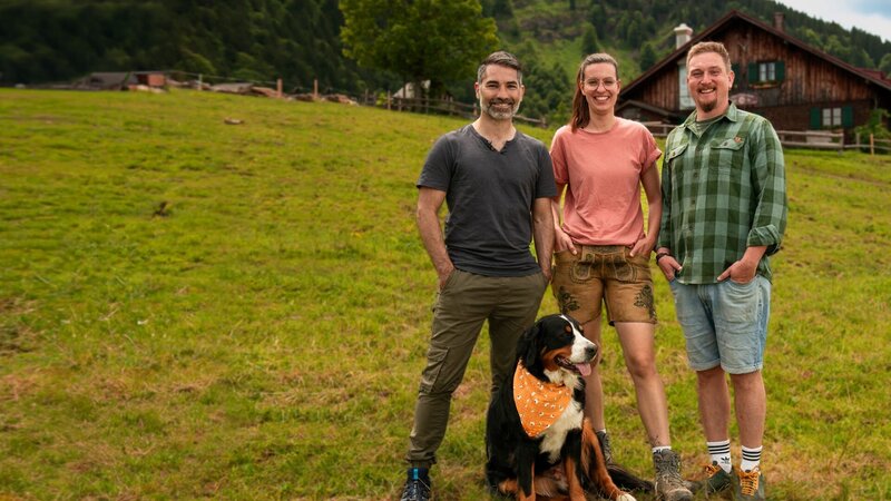 Key Visual/​Cover Sendereihenbild ohne Typo zu „Berghütten mit Marcus Fahn“ mit Moderator Marcus Fahn (links) auf der Alpe Obere Kalle mit Pächter Lisa und Christoph vor der Hütte. – Bild: Matthias Schwinn /​ BR, Watch Lola GmbH