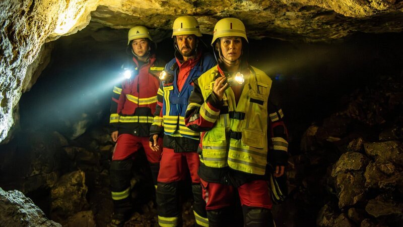 Einsatzkräfte, Flori (Xiduo Zhao, l.), Marie (Christine Eixenberger, M.) und Peter (Stephan Luca), in der Höhle. Dunkelheit, Hoffnung, Gefahr: Peter führt das Team zu den vermissten Jugendlichen. – Bild: ZDF und Susanne Bernhard