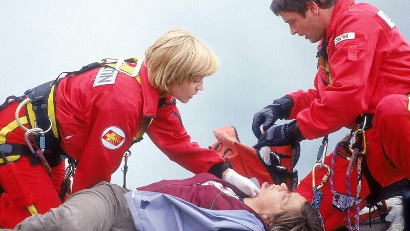 Die verletzte Sylvia (Andrea Dengler) braucht dringend Insulin. Während Karin (Roswithy Meyer, l.) sie versorgt, bittet sie Enrico (Tom Mikulla) loszugehen, um den zurückgelassenen Notfallrucksack zu holen. – Bild: RTL /​ Miguel Dieterich