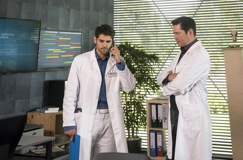 Dr. Philipp Brentano (Thomas Koch, r.) hört mit, als Niklas (Roy Peter Link, l.) am Telefon erfährt, dass Max mit dem Fahrrad gestürzt ist. – Bild: ARD /​ Jens-Ulrich Koch