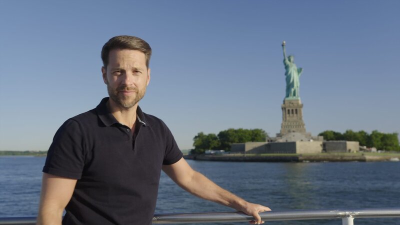 Mirko Drotschmann und die amerikanische Freiheitsstatue im Hafen von New York. – Bild: ZDF und Torbjörn Karvang