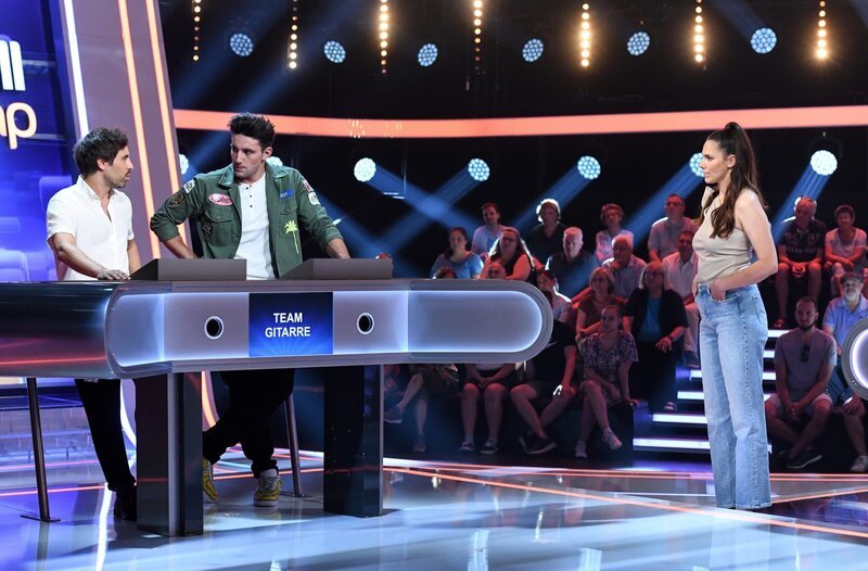 Moderatorin Esther Sedlaczek (r.) mit den Kandidaten des Teams „Gitarre“: Max Giesinger (l.) und Alexander Eder (2.v.l.) beide Musiker. – Bild: ARD/​Uwe Ernst