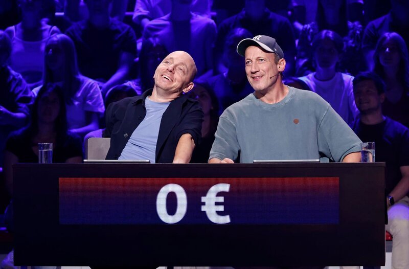 Rateteam-Kapitän Bernhard Hoëcker (l.) mit Schauspieler Wotan Wilke Möhring (r.).; ARD WER WEISS DENN SOWAS? FOLGE 1170, „Wotan Wilke Möhring und Axel Prahl“, am Mittwoch (09.10.24) um 18:00 Uhr im ERSTEN. – Bild: ARD/​Morris Mac Matzen