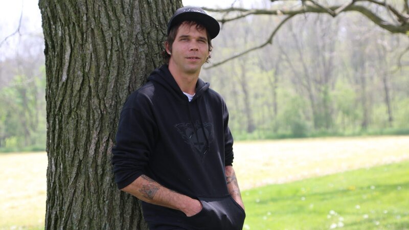 Jeremiah sitting next to a tree. – Bild: Discovery Communications