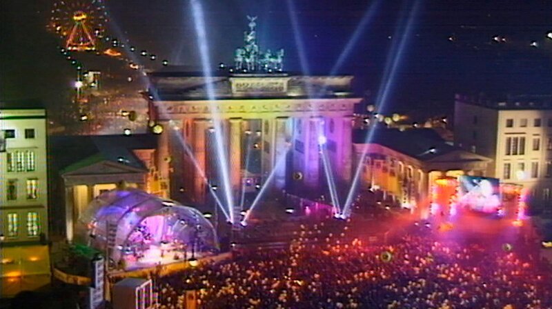 Das Jahr 1999 – Parlament und Regierung ziehen von Bonn nach Berlin in die Hauptstadt, eine Sonnenfinsternis lässt die Berliner für einen Augenblick innehalten und ganz Berlin ist im Millenniums-Fieber: Was wird der Datumswechsel bringen? Eine Berlin-Chronik der Superlative: Vier Jahrzehnte von 1961, dem Jahr des Mauerbaus, bis 1999, als Berlin wieder Hauptstadt eines vereinten Deutschlands ist. – Foto: Jahrtausendparty am Brandenburger Tor. – Bild: rbb
