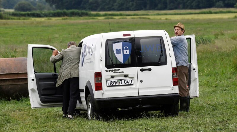 Mit dem schrottreifen Goldtransporter kommen Hajo (Axel Milberg, li.) und Adsche (Peter Heinrich Brix, re.) nicht weit. Als sich die Polizei nähert, schieben sie den Wagen wieder an den Unfallort zurück. – Bild: NDR/​Uwe Ernst