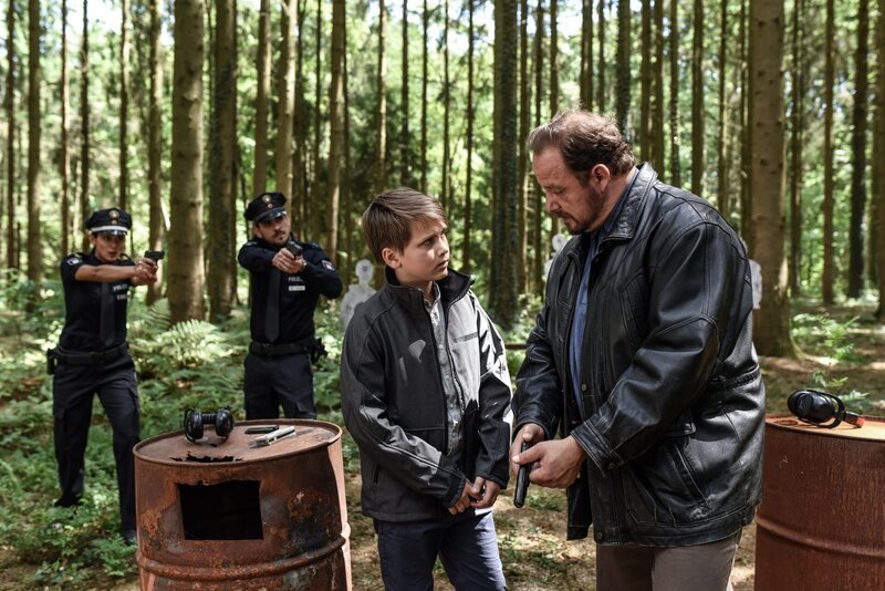 Pinar (Aybi Era, l.) und Kris (Marc Barthel, 2.v.l.) überraschen Uwe Fleischer (Andreas Anke, r.), der seinem Sohn Hermann (Valentin Just, 2.v.r.) auf einem illegalen Schießstand das Schießen beibringt. – Bild: ZDF und Marion von der Mehden
