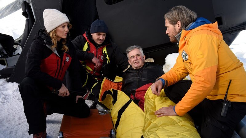 Die Bergretter Katharina (Luise Bähr, l.), Tobi (Markus Brandl, 2. v. l.) und Markus (Sebastian Ströbel, r.) sind froh, ihren Kollegen Michi (Robert Lohr, 2. v. r.) verletzt, aber lebend, gefunden zu haben. – Bild: ZDF und Barbara Bauriedl