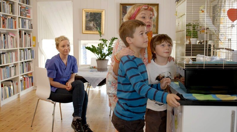 Hugos Mutter und seine Oma freuen sich, dass Hugo und Marlon sich um den Nymphensittich Pablo kümmern wollen (von li nach re: Marte Germaine Christensen, Martin Evensen, Anette Hoff, Petter Mortensen). – Bild: WDR/​NRK Super