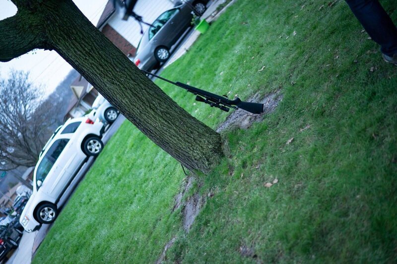 Das Gewehr lehnt an einem Baum – Bild: Bad Move 6 Productions Inc /​ Crime + Investigation