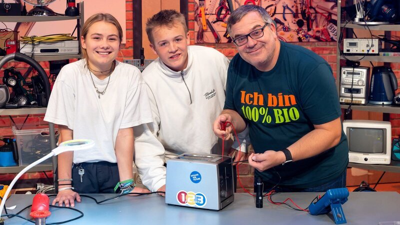 Martha (l.) und Liam (M.) zeigen Elton (r.), wie man alte Elektrogeräte wieder einsatzbereit macht. – Bild: ZDF und Ralf Wilschewski