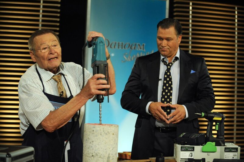 Alois versucht den TV-Moderator als Heimwerkerkönig bei den Porbeaufnahmen zu überzeugen. Von links: Alois Preissinger (Erich Hallhuber sen.) und TV-Moderator Baumann (Robert Jarczyk). – Bild: BR/​Marco Orlando Pichler