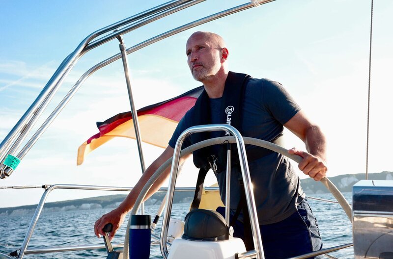 Schauspieler und Ostseeliebhaber Benno Fürmann am Steuer eines Segelschiffes auf der Ostsee während der Dreharbeiten zum Film „Ostsee am Limit“. – Bild: rbb/MDR/Christian Werner Schauspieler und Ostseeliebhaber Benno Fürmann am Steuer eines Segelschiffes auf der Ostsee während der Dreharbeiten zum Film „Ostsee am Limit“. – Bild: rbb/MDR/Christian Werner