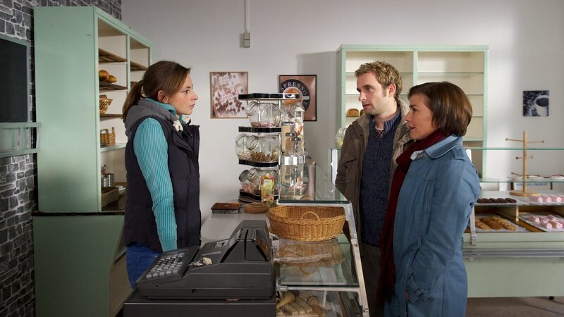 Katrin (Claudia Schmutzler, r.) und Nils (Jonas Laux, M.) müssen Jana Matthiesen (Carolyn Genzkow, l.) eine schlechte Nachricht überbringen: Ihr Vater, der Bäcker Jörn Matthiesen, ist bei einer Wohnwagenexplosion ums Leben gekommen. – Bild: ZDF und Marc Meyerbröker