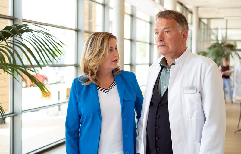 Dr. Roland Heilmann erzählt Sarah Marquardt, dass seine Tochter Lisa einen Freund hat. – Bild: BR/​MDR/​Robert Strehler