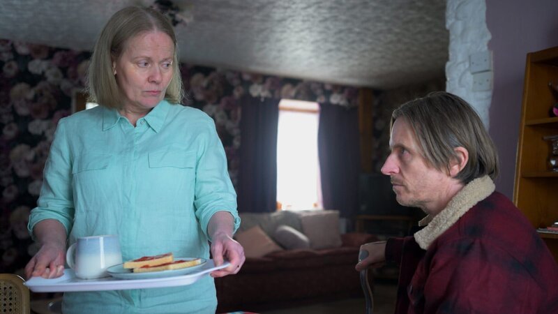 Nach Jahren, in denen sie keinen Kontakt zueinander hatten, besucht Adrian (Oliver Ryan), der sich Andrew nennt, seine Mutter Pat (Caroline Berry) in ihrem Haus. – Bild: ZDF und Warren Orchard