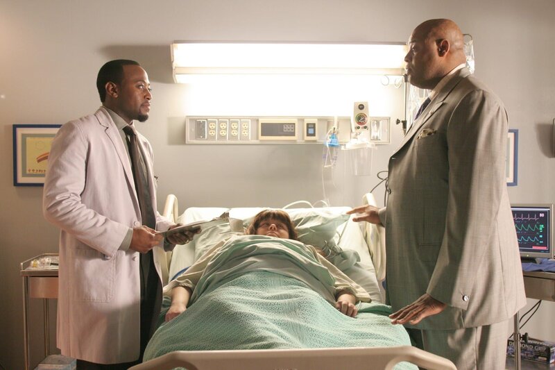 Die übergewichtige Jessica Simms (Jennifer Stone, M.) hat offensichtlich einen Herzanfall erlitten. Edward Vogler (Chi McBride, r.) scheint immer mehr die Arbeitsweise von den Ärzten, auch die von Dr. Eric Foreman (Omar Epps, l.), zu kontrollieren. – Bild: FOX BROADCASTING COMPANY