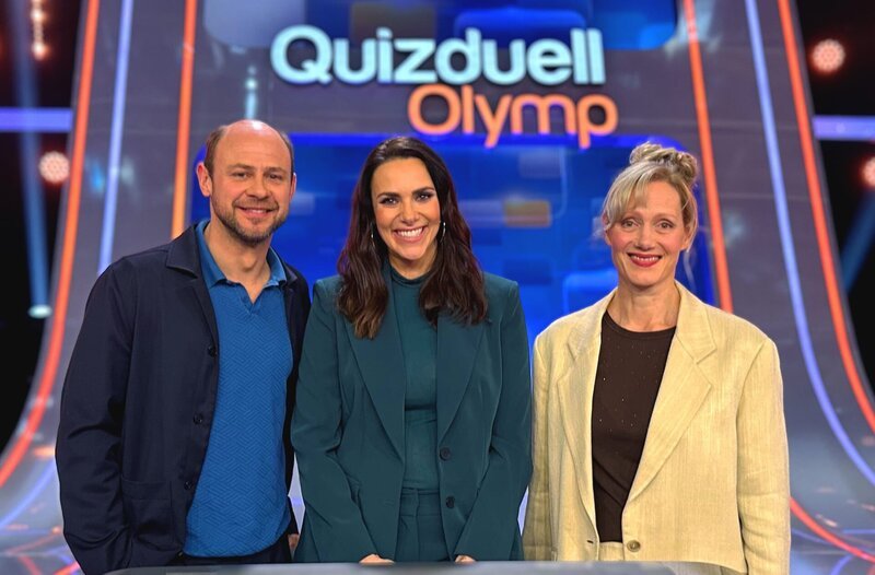 Moderatorin Esther Sedlaczek (M.) mit den Kandidaten des Teams „Schauspiel“: Moritz Führmann (l.) Anna Schudt (r.). – Bild: ARD/​ITV Studios