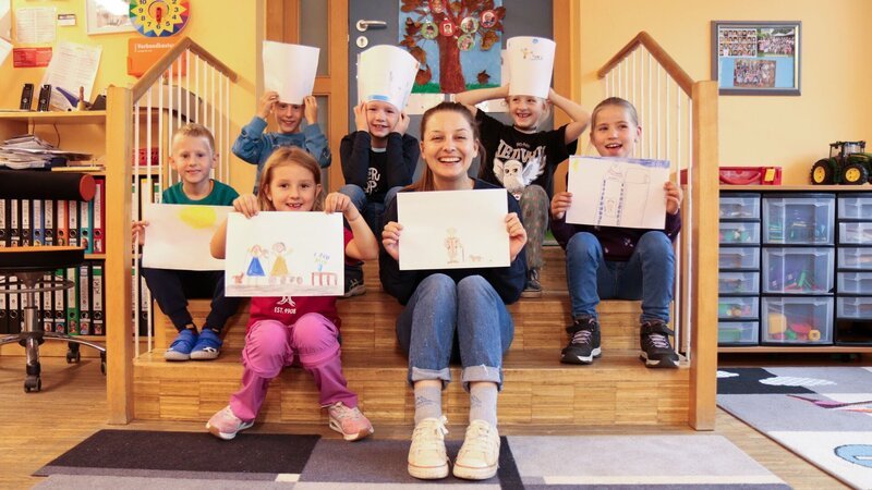 Checkerin Marina besucht Schulkinder und malt mit ihnen ein Bild, wie sie sich alte Menschen vorstellen. Mit den Bildern gehen sie in ein Altenheim und besuchen die Bewohner und Bewohnerinnen. – Bild: BR/​megaherz gmbh/​Franziska Gruber