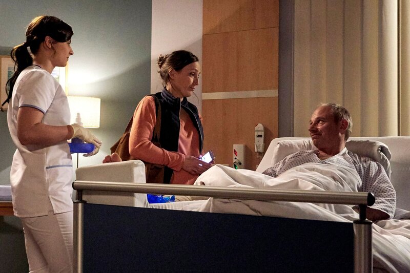 Udo Schweikert (Michael Lott, re.) hat sich das Sprunggelenk gebrochen. Er wird gerade von Schwester Nadine Meyer (Julia Schäfle, li.) versorgt, als seine Frau Susi (Lotte Ohm, mi.) besorgt und gestresst in die Sachsenklinik kommt. Susi und Udo haben ein Lokal von Susis Eltern geerbt, welches sie wiedereröffnen wollen. Nun sind sie kurz vor der Eröffnung und Udo fällt aus. Noch dazu muss Udos Spedition auch weiterlaufen und die kleine Tochter will auch versorgt werden. – Bild: MDR/​Saxonia/​Kiss