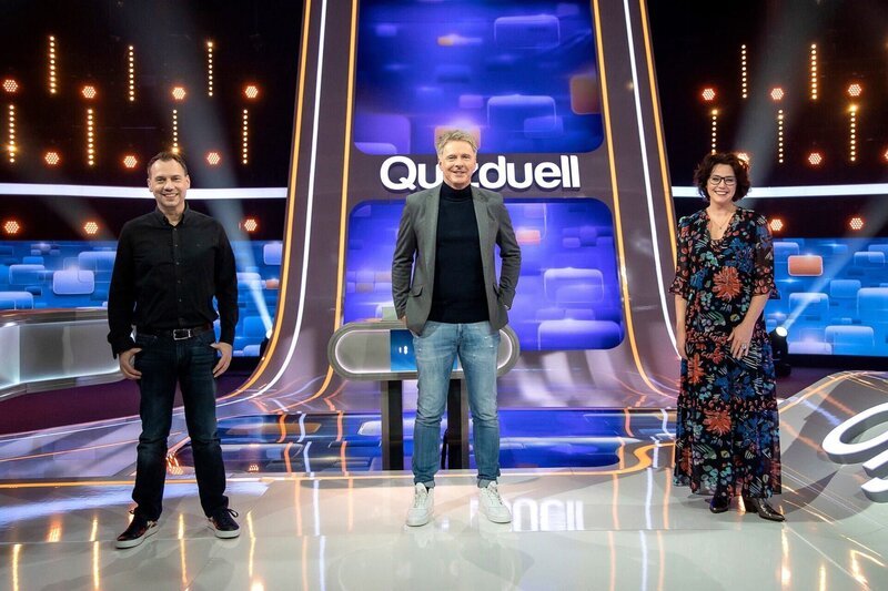 Moderator Jörg Pilawa (M.) mit den KandidatInnen des Teams „Bestseller“: Dem Schriftsteller Sebastian Fitzek (l.) und der Schriftstellerin Ildikó von Kürthy (r.). – Bild: ARD/​Arne Vollstedt