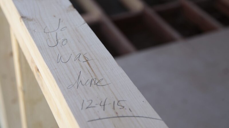Joanna Gaines leaves her mark on a beam in the Ward’s carriage house while Chip works to frame out new walls, as seen on Fixer Upper. – Bild: HGTV/​Scripps Networks, LLC.