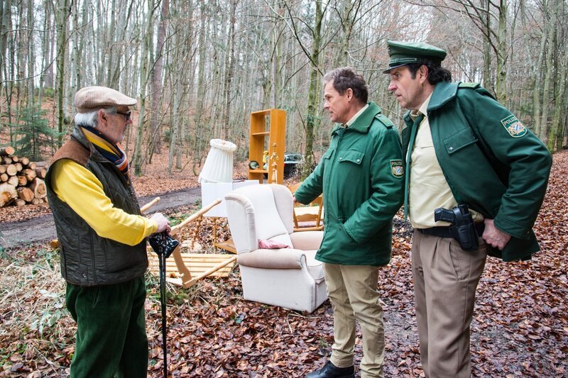 Hubert (Christian Tramitz, 2.v.r.) und Staller (Helmfried von Lüttichau, r.) werden zu einem Fall von illegaler Müllentsorgung gerufen. Ein Rentner (Sandro Di Stefano, l.) zeigt ihnen die Stelle im Wald. – Bild: ARD/​BR/​TMG/​Chris Hirschhäuser/​Chris Hirschhäuser
