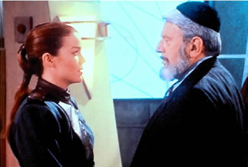 Susan Ivanova (Claudia Christian, l.) begrüßt auf Babylon 5 Yossel Koslov (Theodore Bikel, r.), einen Rabbi aus Rußland, der gekommen ist, um Susan das Erbe ihres verstorbenen Vaters zu überbringen. – Bild: Tele 5