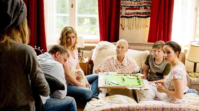 Der Familien-Spieleabend läuft völlig aus dem Ruder: Leah (Charlotte Krause, l.) will nicht glauben, dass ihre Family ernsthaft die verstaubte Spielesammlung hervorkramt, Tobias (Matthias Komm, 2.v.l.) will nicht in Waltrauds (Hedi Kriegeskotte, M.) Zimmer rumsitzen, Luca (Luis Kain) weiß gar nicht, was eine „Spielesammlung“ ist und Cornelia (Brigitte Zeh, 3.v.l.) ist enttäuscht. Doch Magda (Verena Altenberger) ist nicht bereit, so schnell aufzugeben … – Bild: TVNOW /​ Reiner Bajo