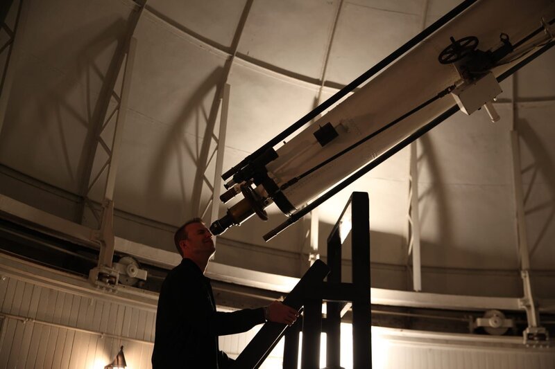 Chad Jenkins schaut durch ein Teleskop im U.S. Naval Observatory. – Bild: Discovery Communications, LLC