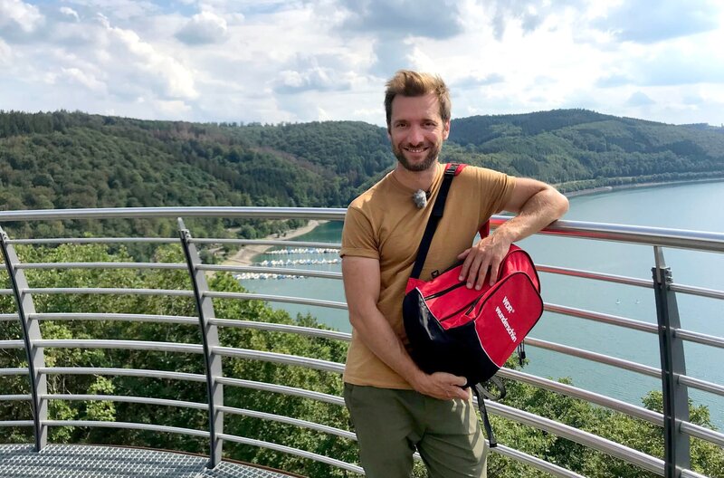 Urlaub am Wasser? Da hat das Sauerland einiges zu bieten. Daniel Aßmann erlebt jede Menge Abenteuer rund um die großen Stauseen. – Daniel Aßmann am Biggesee. – Bild: BR, WDR, Bavaria Entertainment GmbH